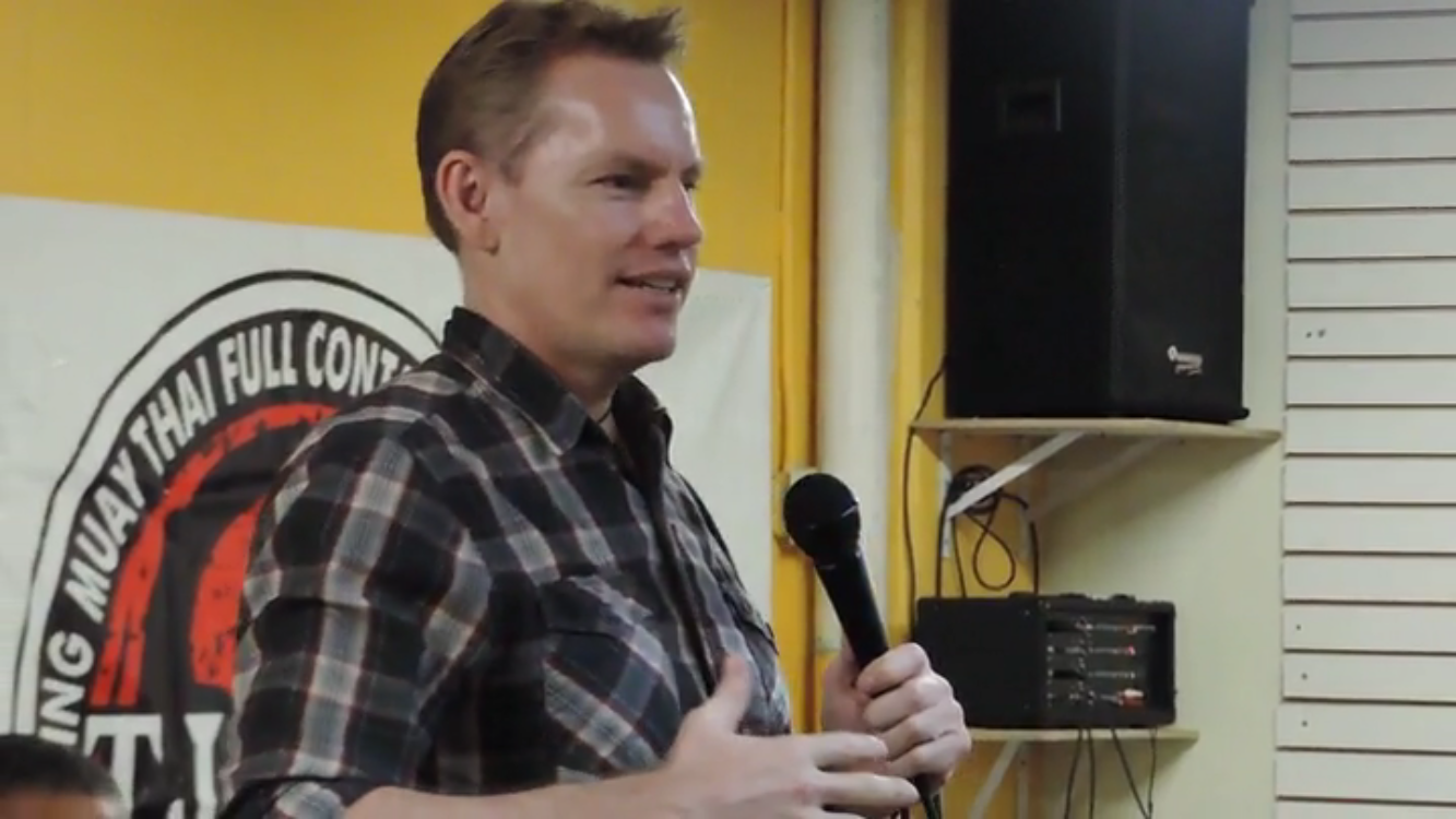 Rick Tew speaking with a microphone