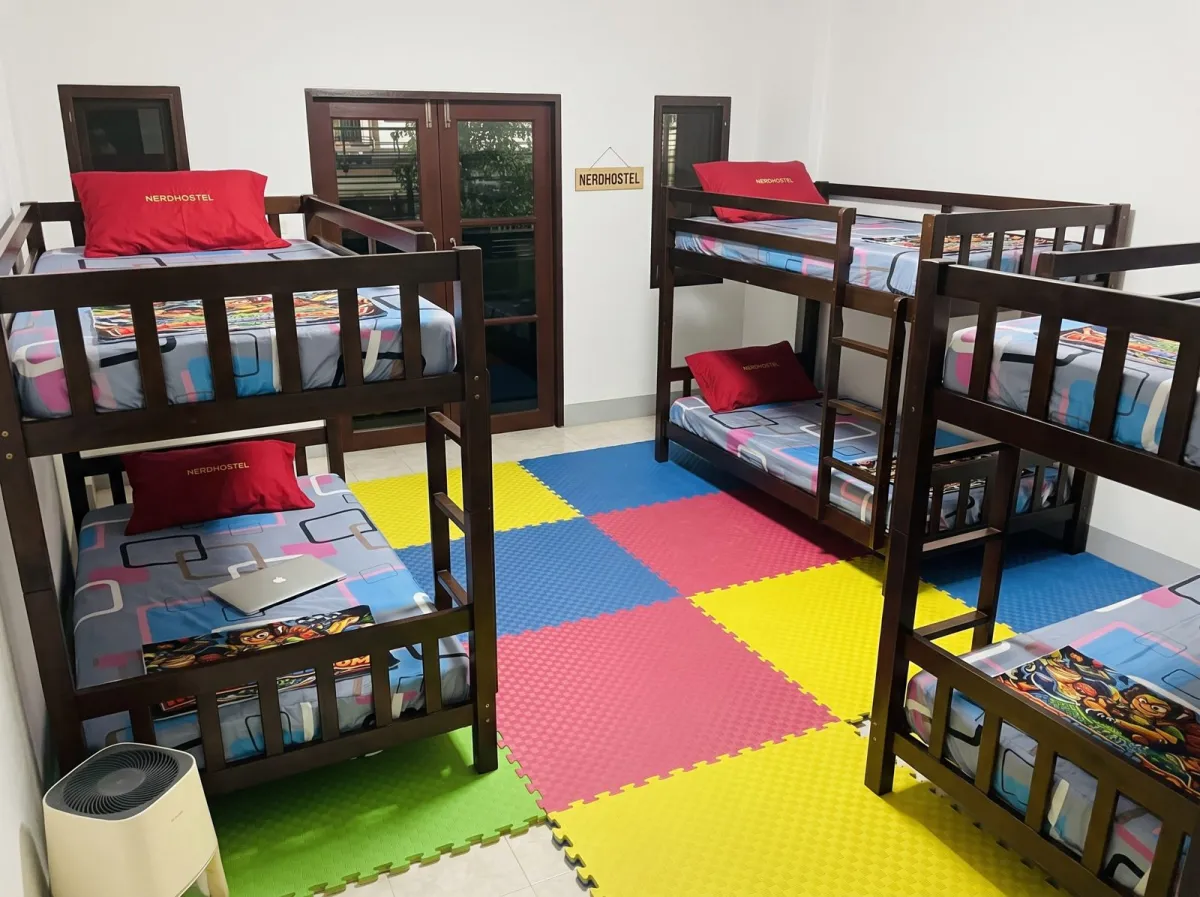 A dorm: wooden bunk beds with red pillows